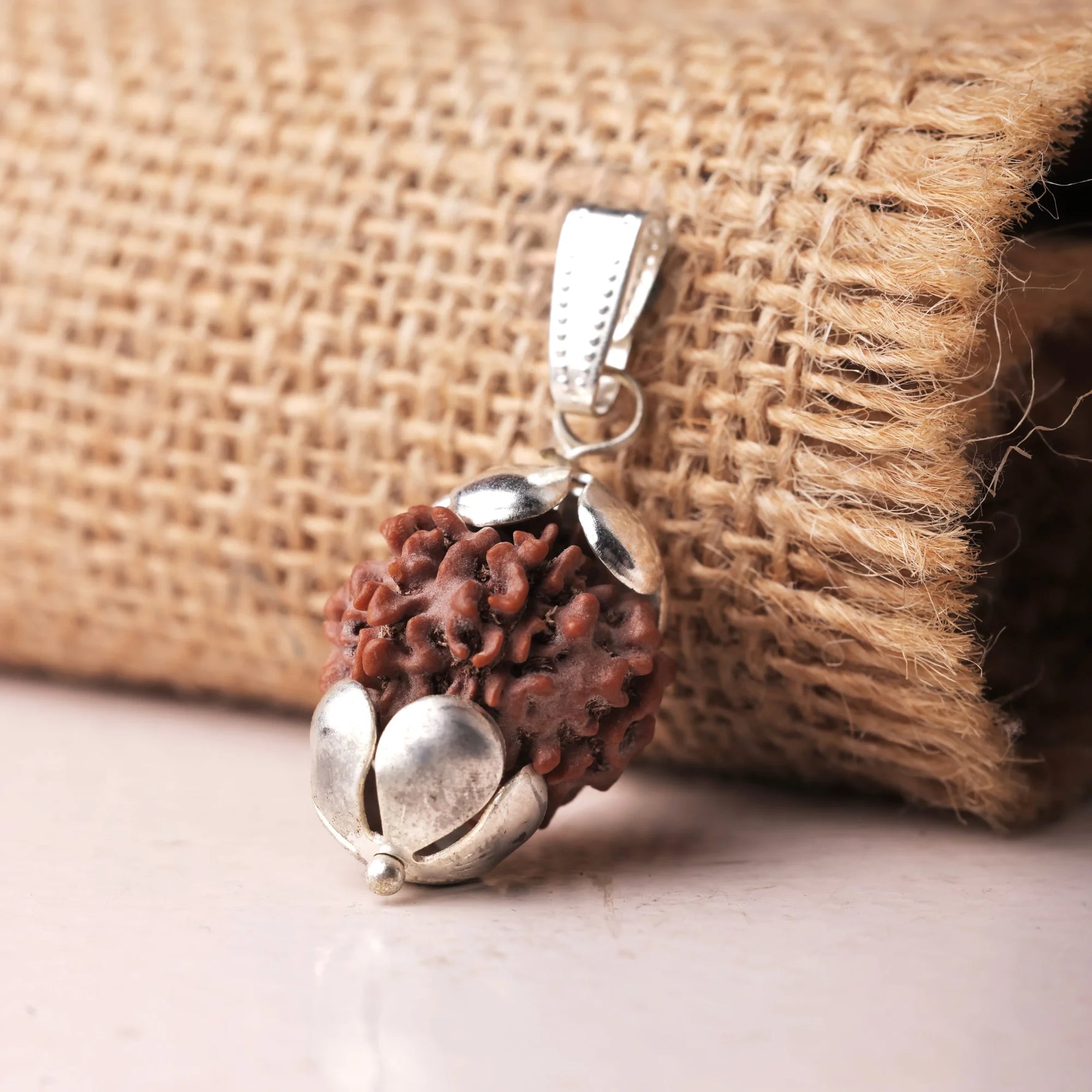 Close-up of authentic 7 Mukhi Rudraksha pendant showing handcrafted ornate silver cap detail