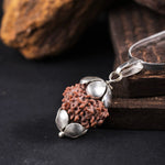 7 Mukhi Rudraksha pendant with silver chain placed on dark wooden background — Mahalakshmi bead
